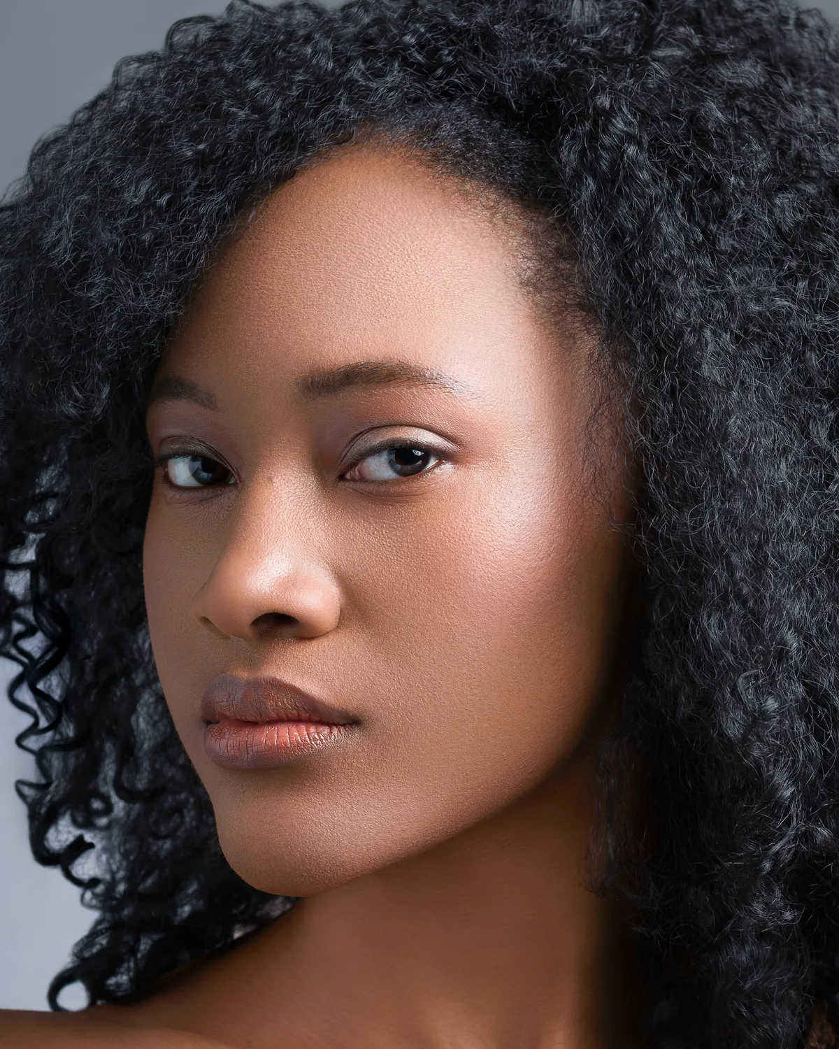 Close headshot of Ahdis Beruk, hair down, against a grey background